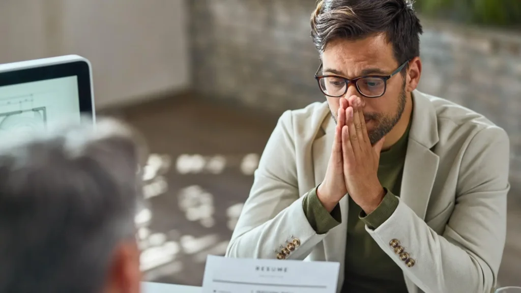 Job candidate appearing concerned during an interview after receiving a suspicious recruitment message.