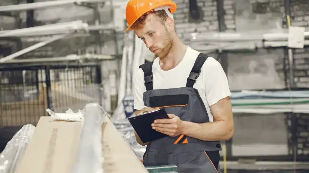Maintenance technician performing equipment inspection in a plastics manufacturing production facility.